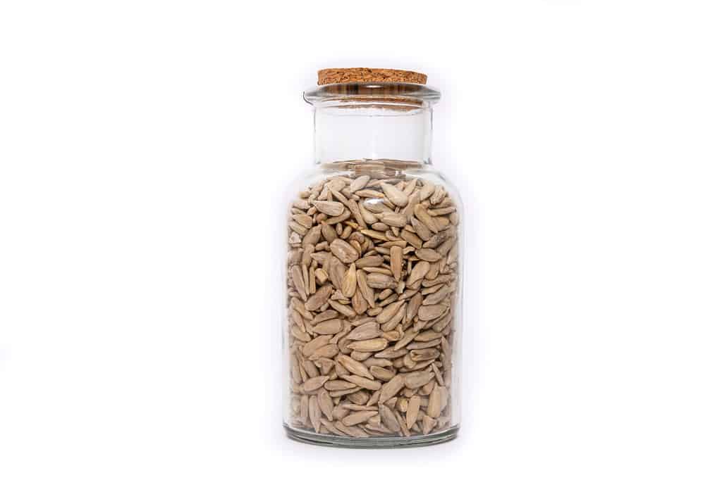 A Jar of dried Sunflower seed isolated on a white background, nutritious seeds dried and stored. Healthy food choice.