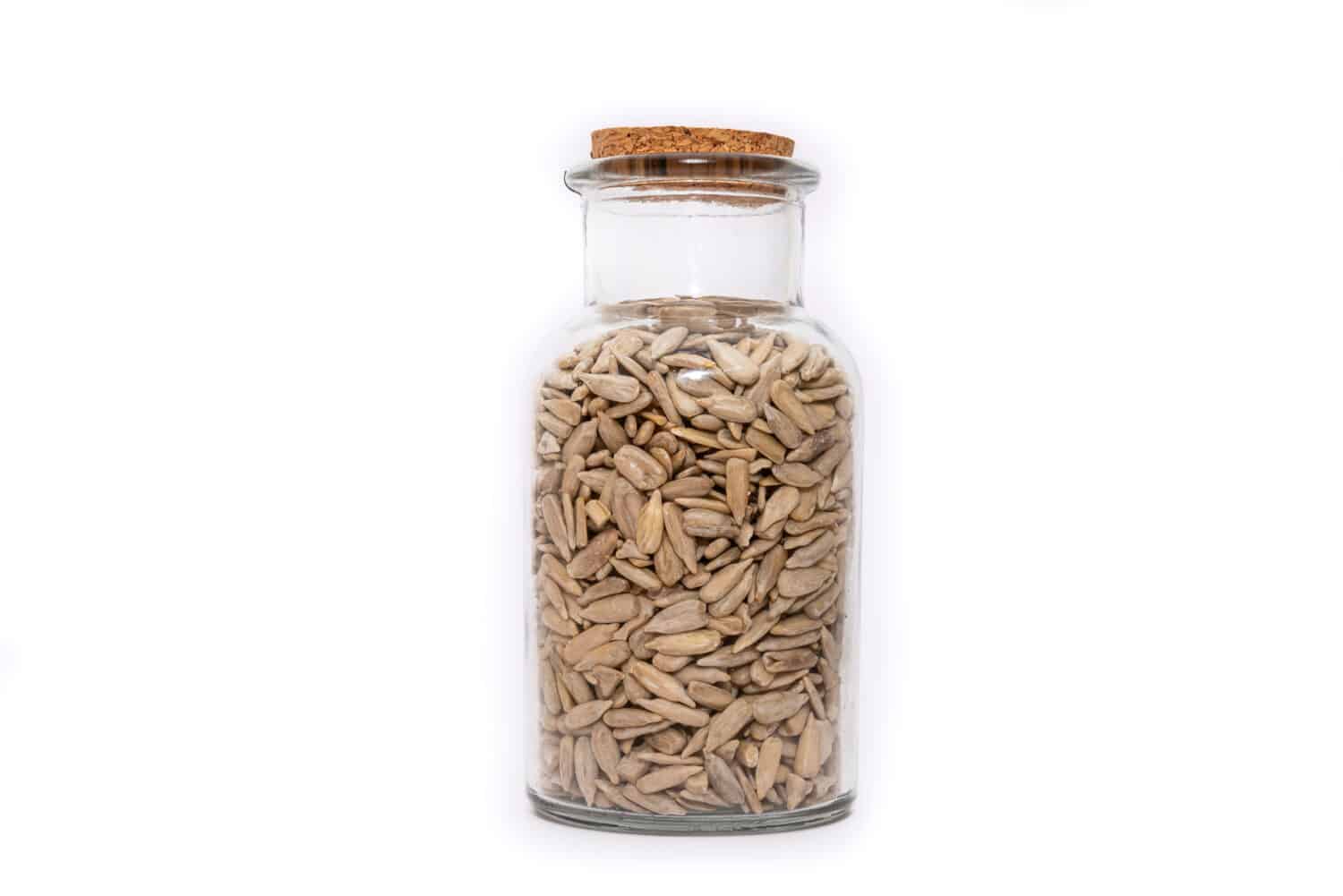 A Jar of dried Sunflower seed isolated on a white background, nutritious seeds dried and stored. Healthy food choice.