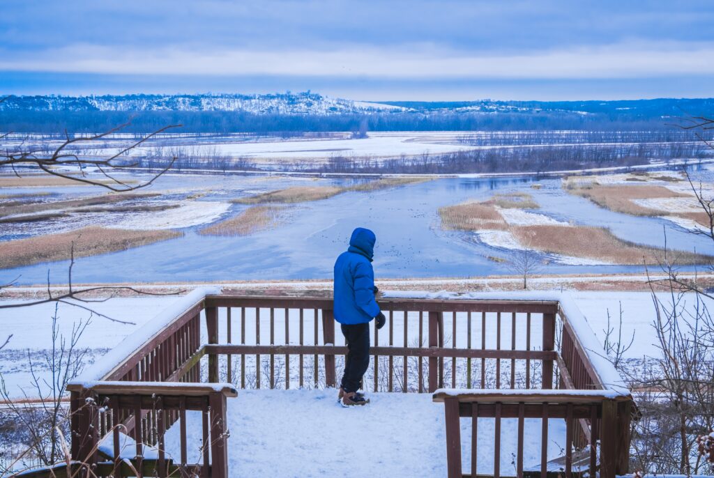 Man looking down at frozen Missouri River 