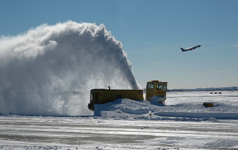 A snow blower does its work at Boston Logan International Airport.