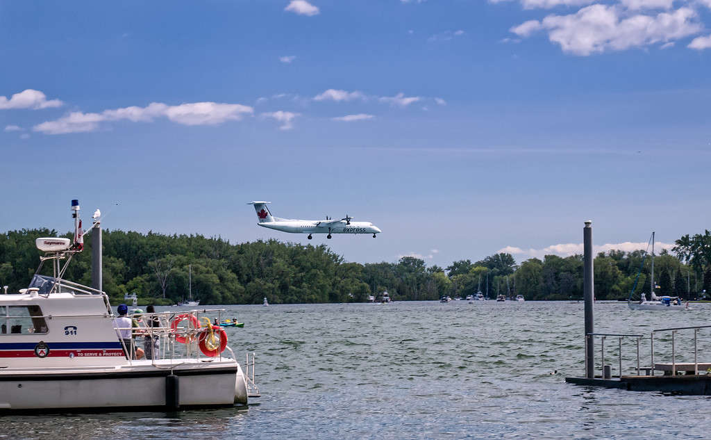 Air Canada turboprop aircraft descending to Billy Bishop Toronto City Airport above the waters of the Toronto Harbour.
