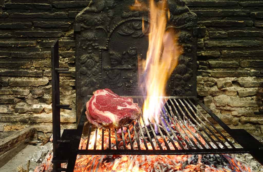 The rib steaks (cote de boeuf) being grilled on an open fire