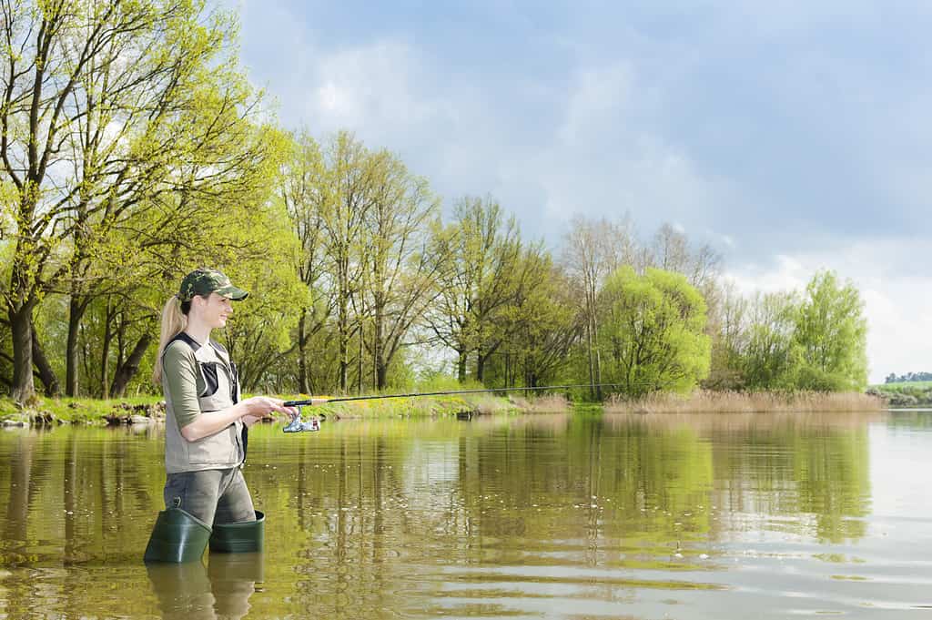 woman fishing in pond in spring