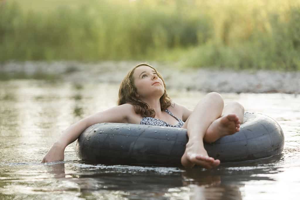 Teen Girl Daydreaming Floating in Inner Tube