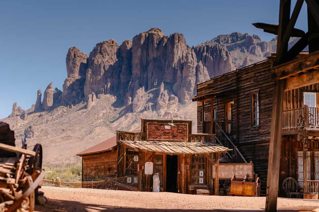 Old Western Wooden Buildings in Goldfield Gold Mine Ghost Town in Youngsberg, Arizona, USA surrounded by cactuses