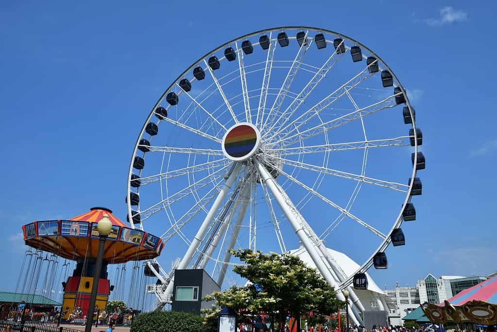 Daytime photo of Chicago’s Navy Pier Centennial Wheel ferris wheel in the summer with swing ride in the foreground