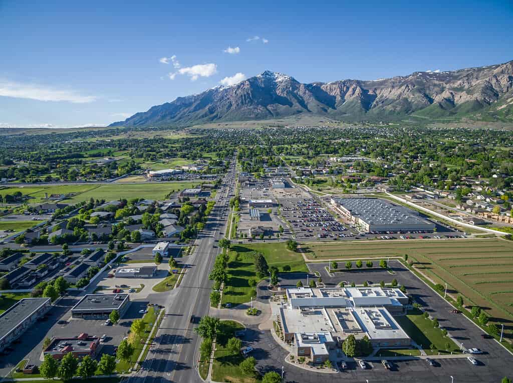 Aerial view from a drone of Washington Blvd and the commercial district of North Ogden, Utah with Ben Lomond Peak and the Wasatch Mountains visible in the background