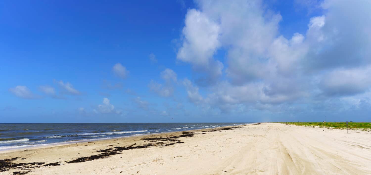 The deserted beach at Rutherford Beach, Cameron Parish, Louisiana, on the Gulf of Mexico, with blue sky and gentle surf.