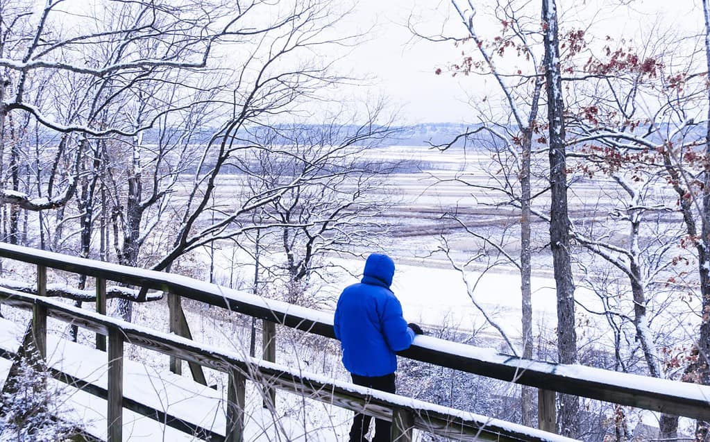 frozen Missouri River floodplain on cold winter day in Midwest; Missouri River bluffs in background