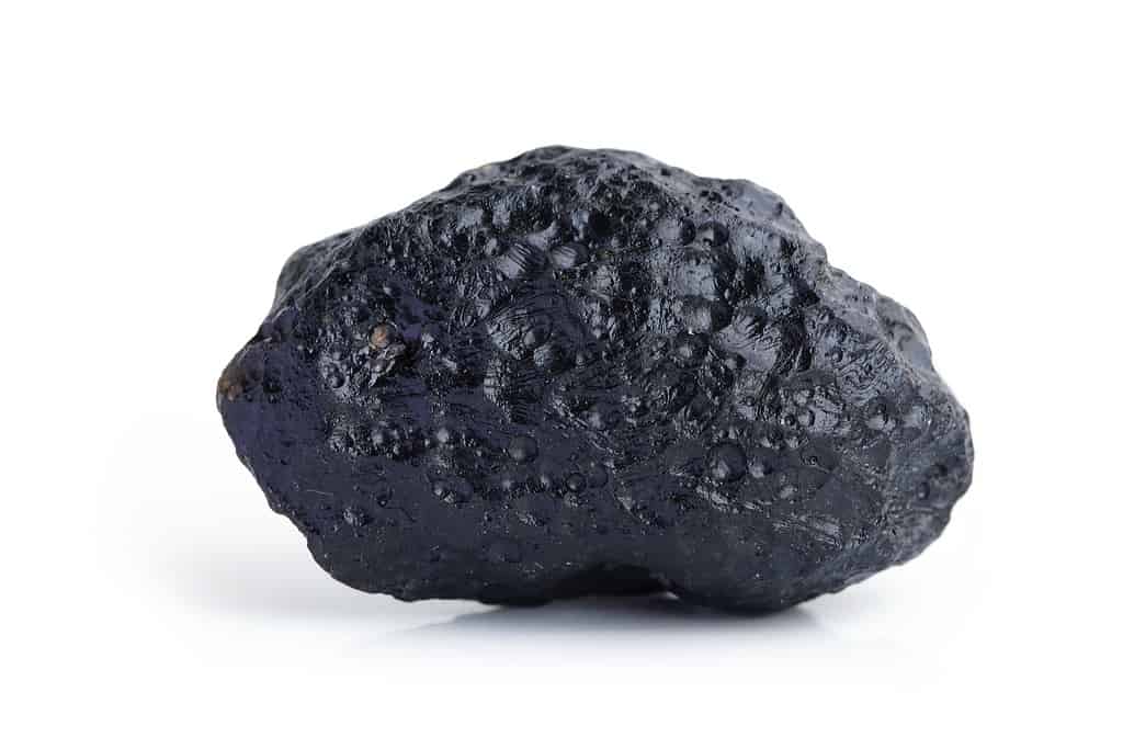 Meteorite black stone rock isolated on white background.
