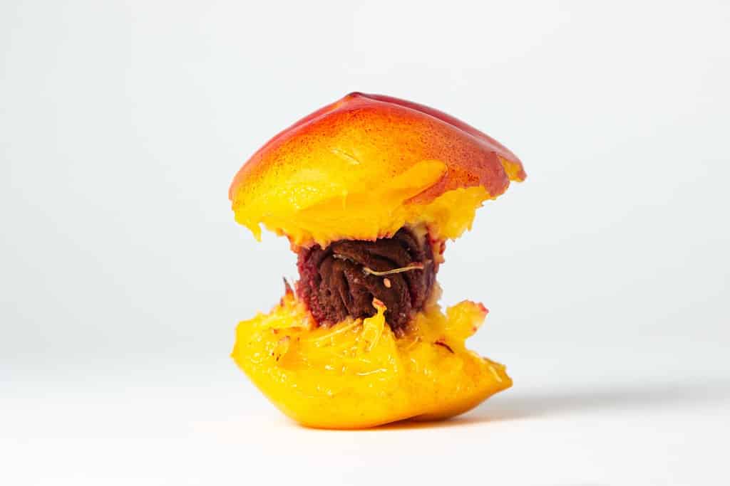 Bitten peach on a white background. Delicious and juicy fruit. peach core