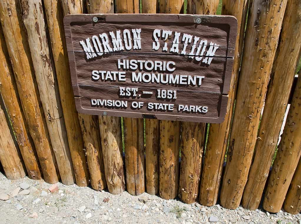 Mormon Station State Park Sign. The sign is made of wood and is attached to a wooden fence. 