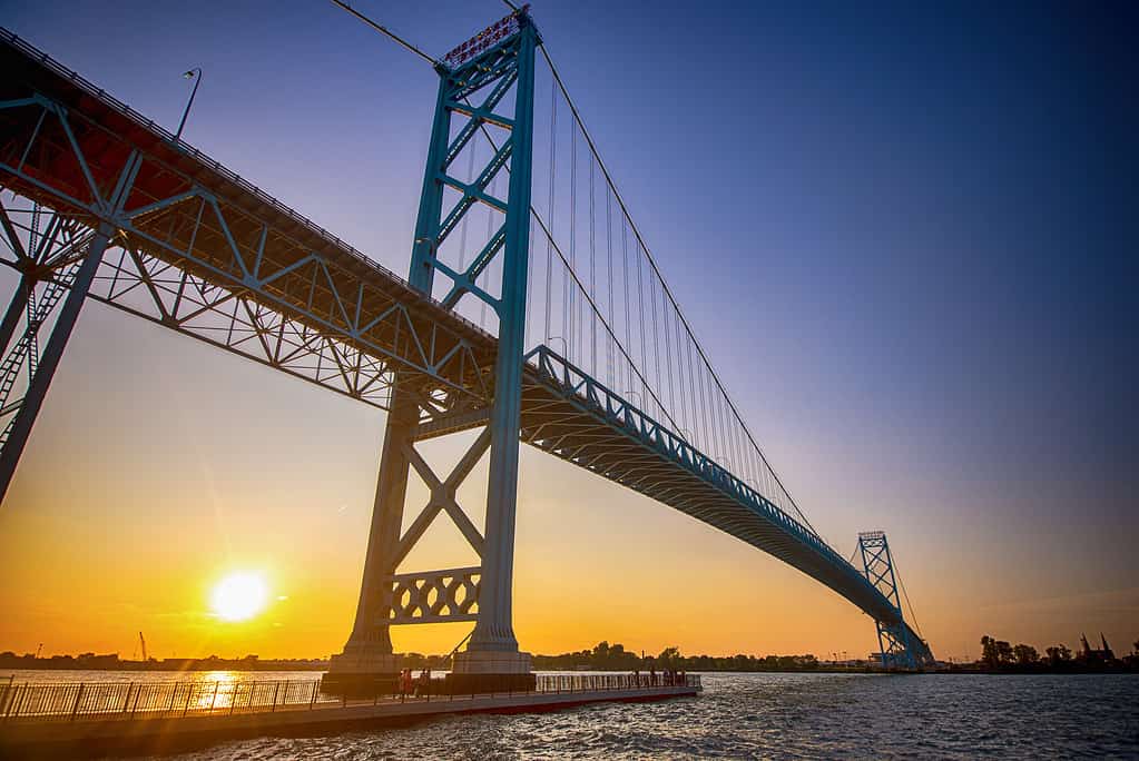 View of Ambassador Bridge connecting Windsor, Ontario to Detroit Michigan at sunset time