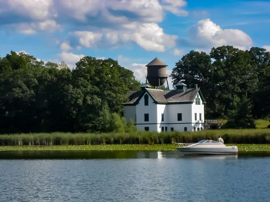 A house in the woods surrounded by a lake