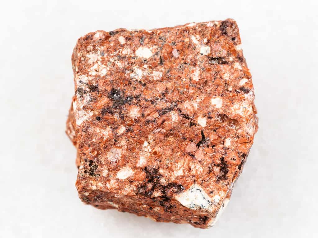 macro shooting of natural mineral rock specimen - rough Dacite stone on white marble background