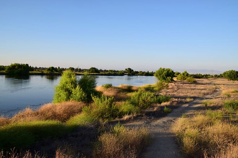 One of the many dirt trails with scenic views along Kern river. Visitors can ride bikes or walk the different trails of Kern River Parkway, Bakersfield, CA.