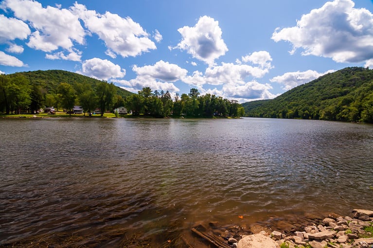A bend in the Allegheny river in Warren county, Pennsylvania, USA on a sunny summer day with a bright blue skies and white clouds