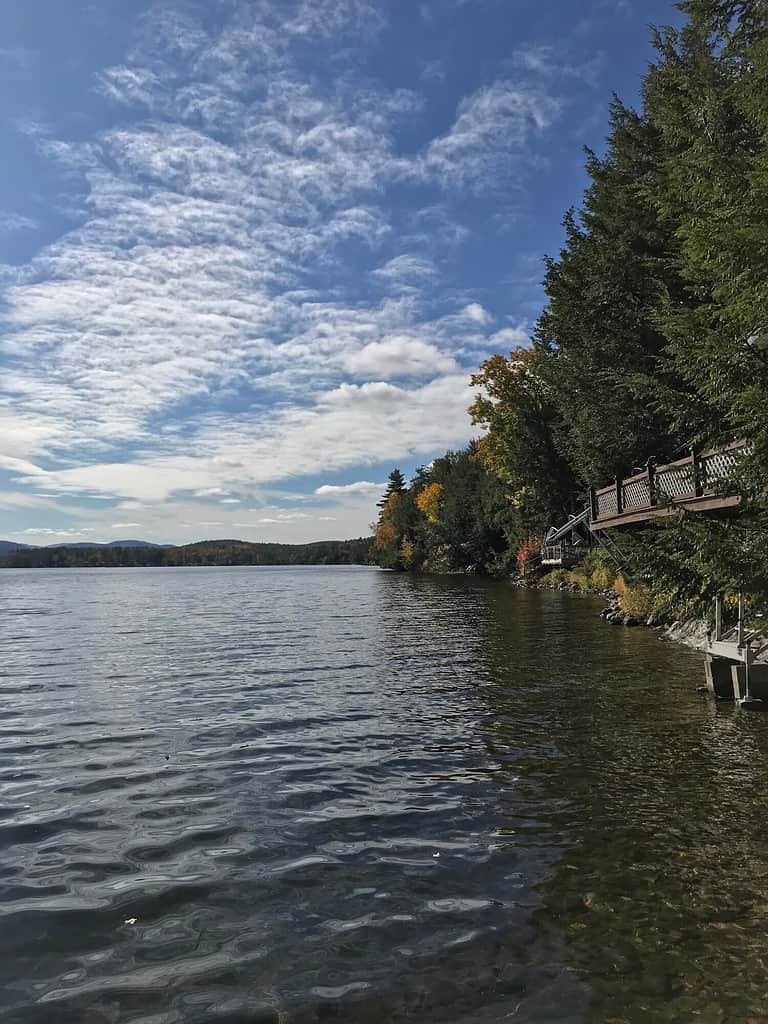 View from a lake house in Vermont. The fluffy clouds reflect on Lake Saint Catherine on a breezy fall day.