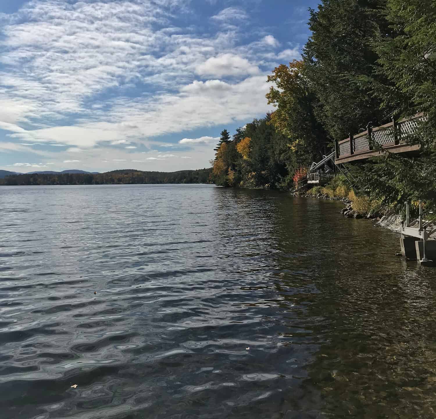 View from a lake house in Vermont. The fluffy clouds reflect on Lake Saint Catherine on a breezy fall day.