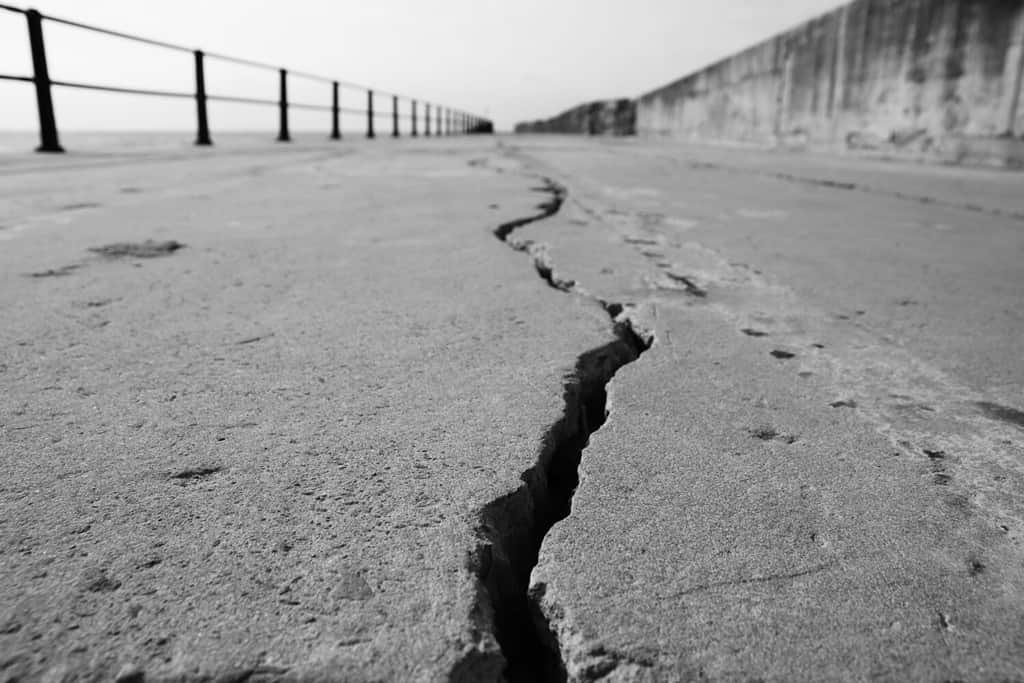 A large crack in concrete. Earthquake concept photo. This picture has selective focus.