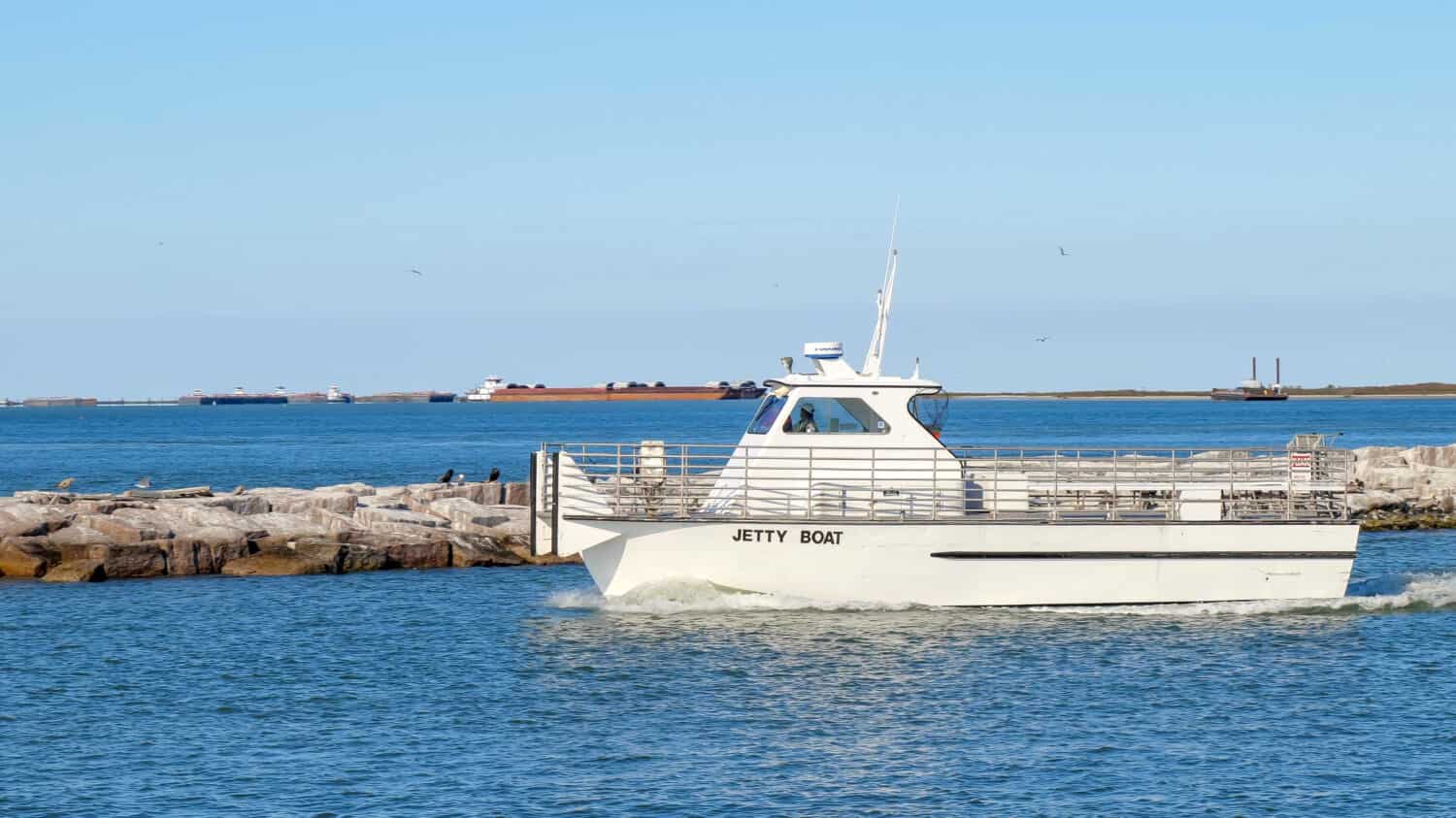 PORT ARANSAS, TX - 27 FEB 2020: Jetty boat leaves the marina entrance on a sunny day as it goes to retrieve passengers from San Jose Island.