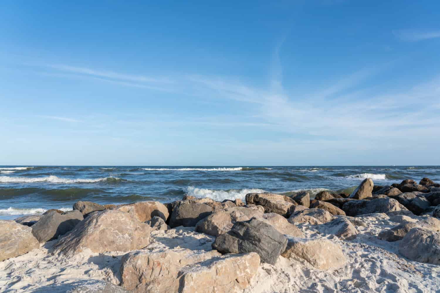 Look out over rocks at Alabama Point East in Orange Beach, AL. This body of water is the Gulf of Mexico.