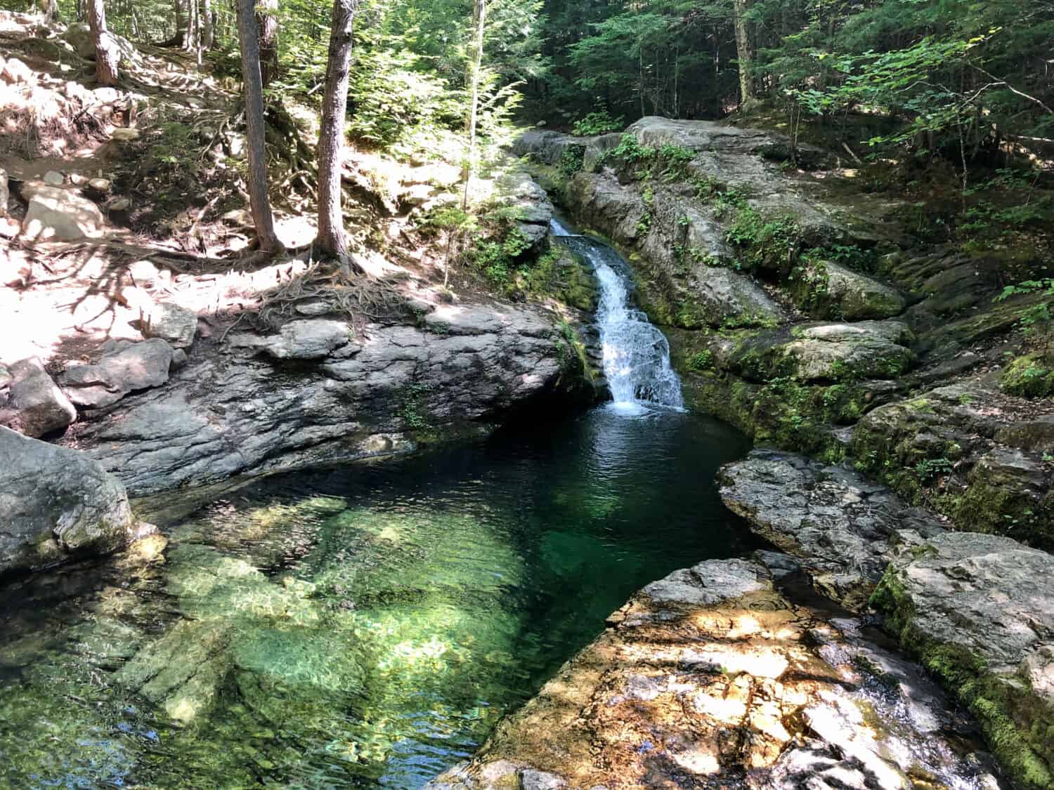 Emerald green Rattlesnake Flume Pool and waterfall in Maine near Fryeburg in summer