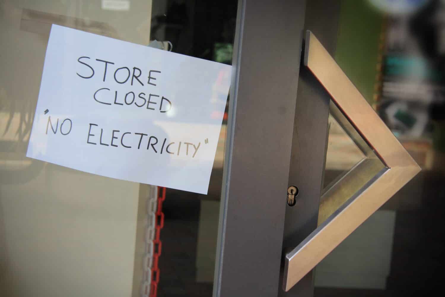 Sign posted in a shop window: Shop closed, no electricity. Energy crisis, blackouts concept.