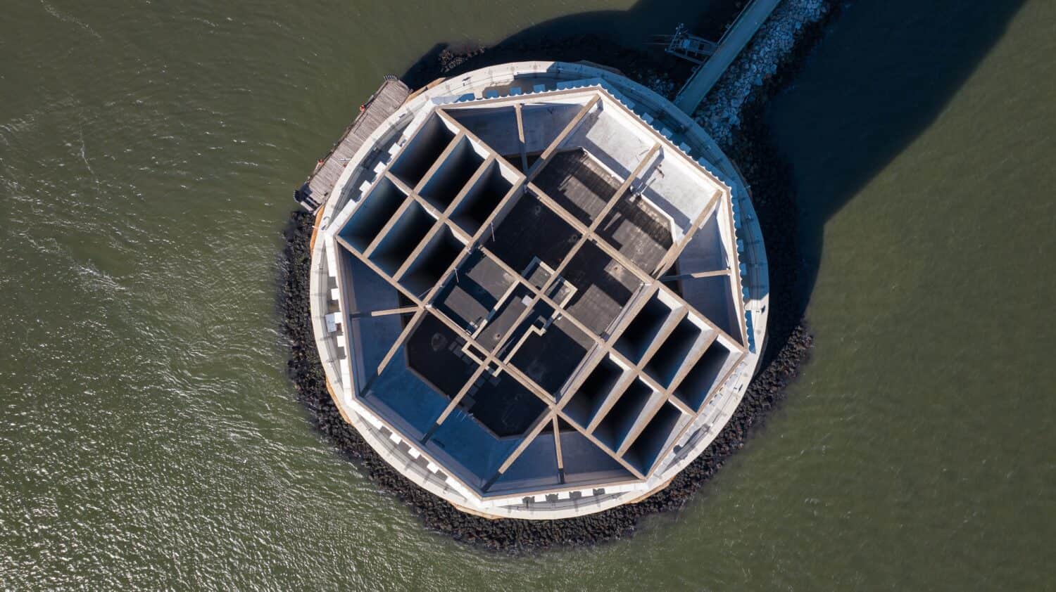 A top down view directly above the Brooklyn Battery Tunnel ventilation tower off of Governors Island in New York City on a sunny day.