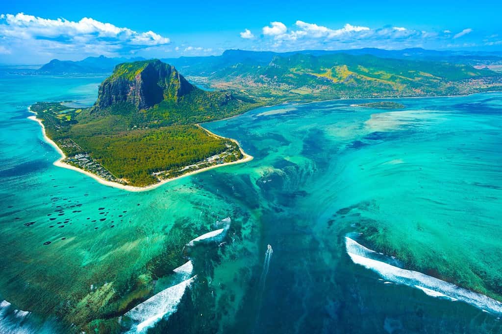 Aerial view of Mauritius island and Le Morne Brabant mountain with beautiful blue lagoon and underwater waterfall illusion