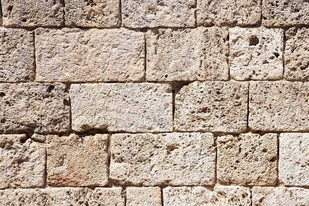 A background with an italian wall made of old textured tuff blocks