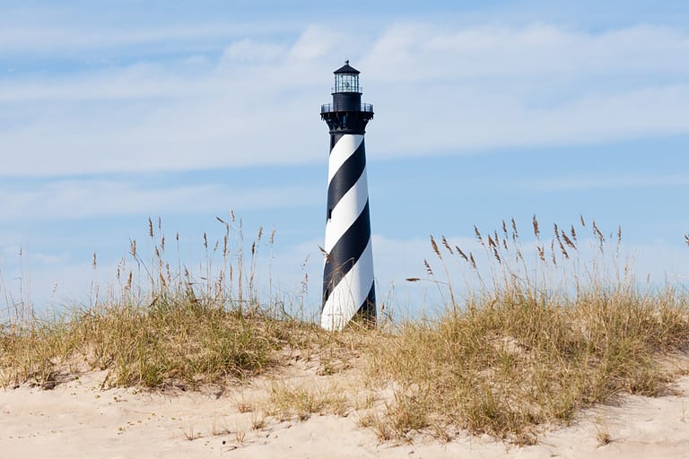 Cape Hatteras Lighthouse towers over beach dunes of Outer Banks island near Buxton, North Carolina, US