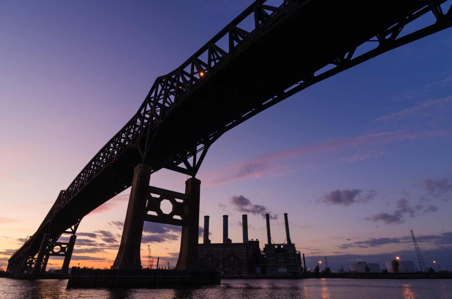 Bridge and industrial area silhouetted at sunset