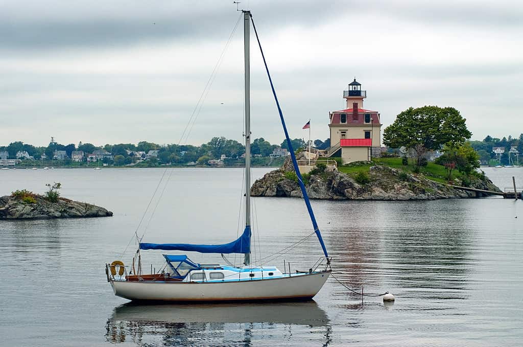 Too cloudy for sailing near Pomham Rock Lighthouse in Providence, Rhode Island. Sailboat is moored near lighthouse for protection.