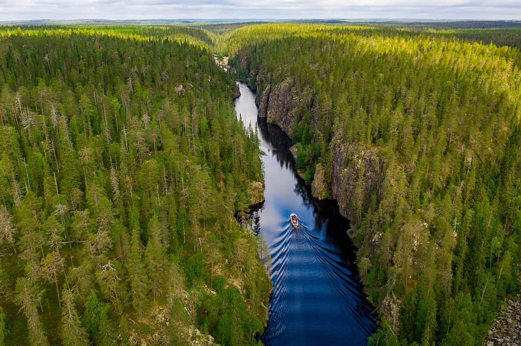 Aerial view of a boat, canyon lake and forest in Julma-Ölkky, Hossa National Park, Finland