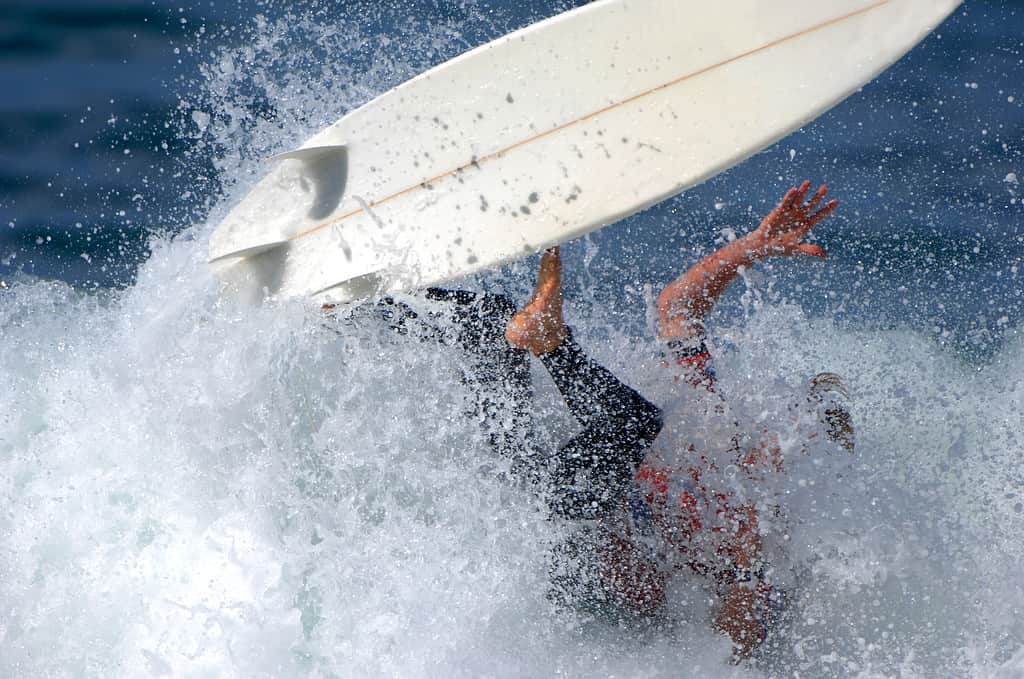 A surfer wipes out while trying to ride a large wave.