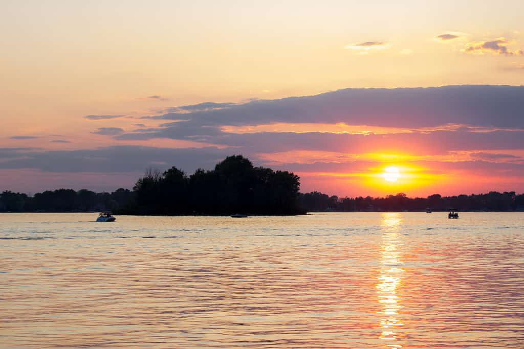 Warm sunset in the summertime at Dewart Lake in Syracuse Indiana with boats cruising over the water