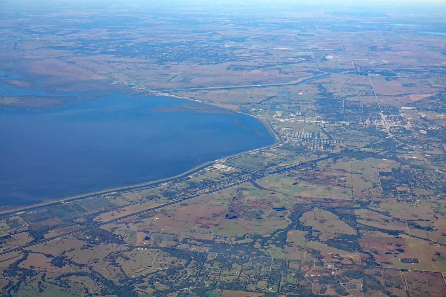 Aerial view of the town of Okeechobee, on the north shore of Lake Okeechobee, with the Kissimmee River flowing into the lake, causing algae pollution.