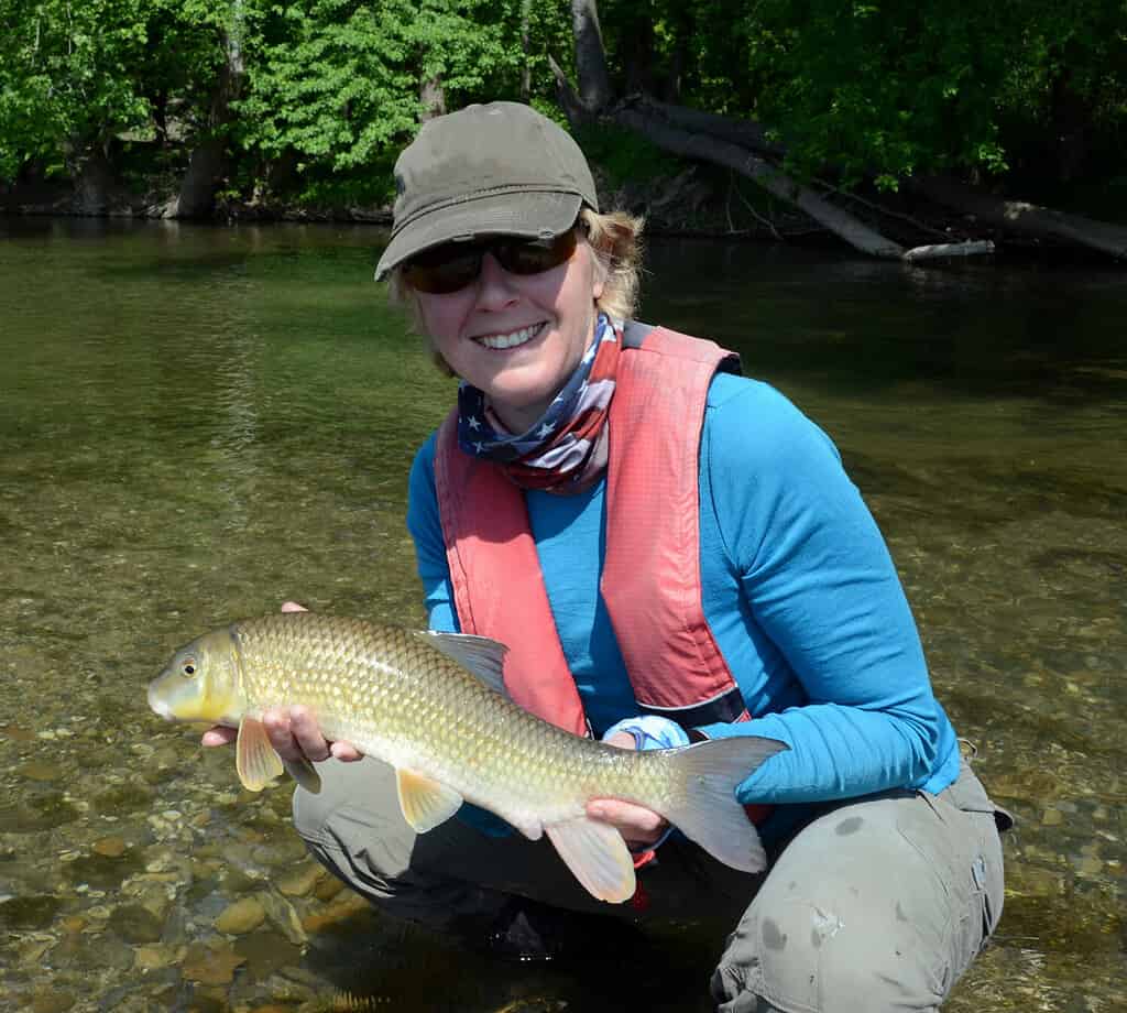 Woman with blue shirt holding fish