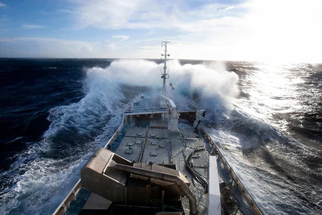 Large deep sea fishing boat scene from the bridge of the boat large wave hitting the bow of the boat