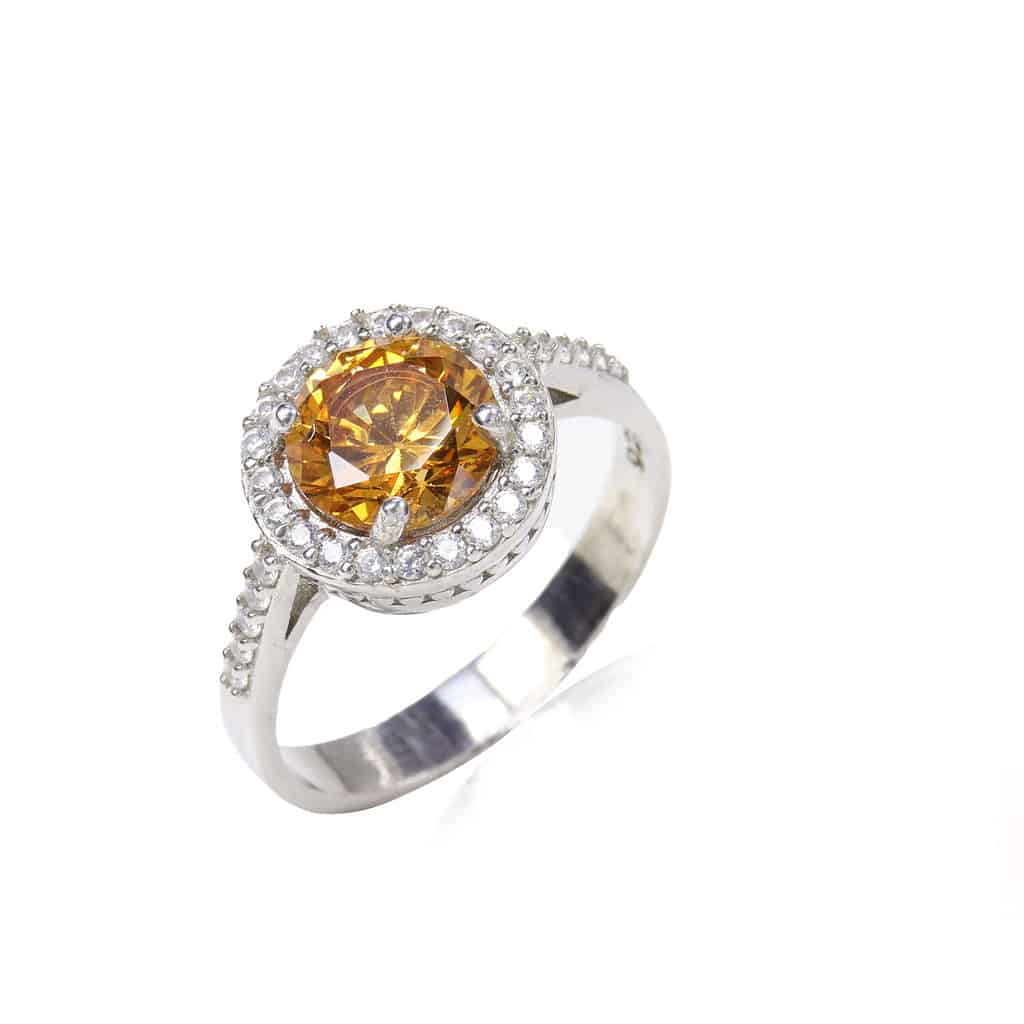 orange gemstone diamond ring on white background
