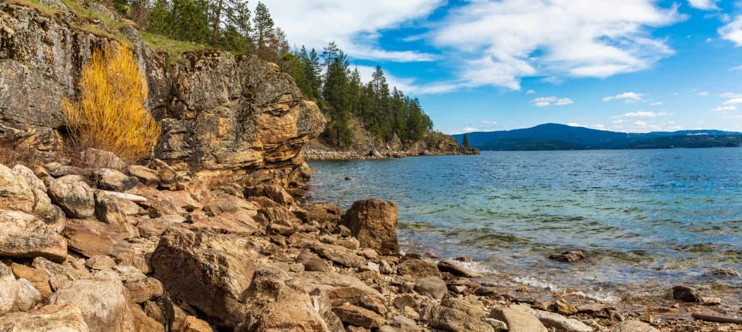 Rocky beach on lake Coeur d'Alene with shoreline background