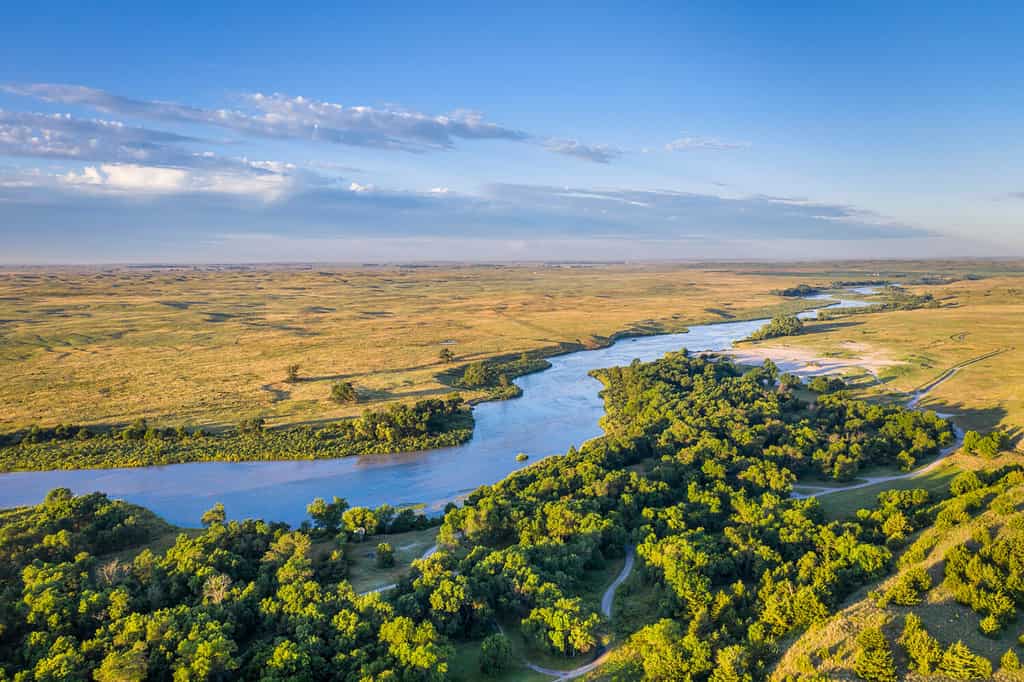 shallow and wide Dismal River flowing through Nebraska Sandhills at Nebraska National Forest, aerial view of morning summer scenery