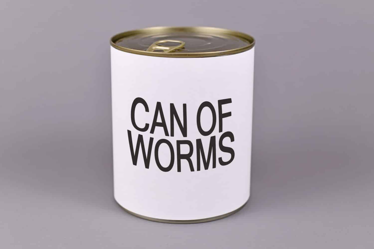 Concept for difficult situations and unpleasant experiences showing a tin can with white label and words 'Can of worms' on gray background