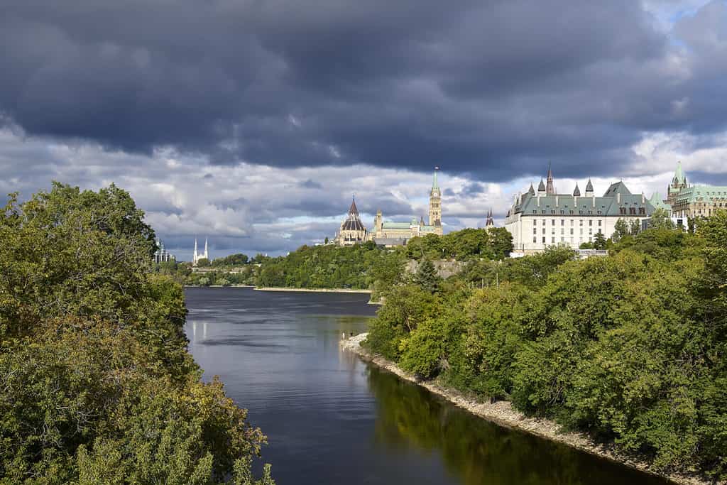 The Ottawa River surrounded with trees under the cloudy sky in Ontario, Canada