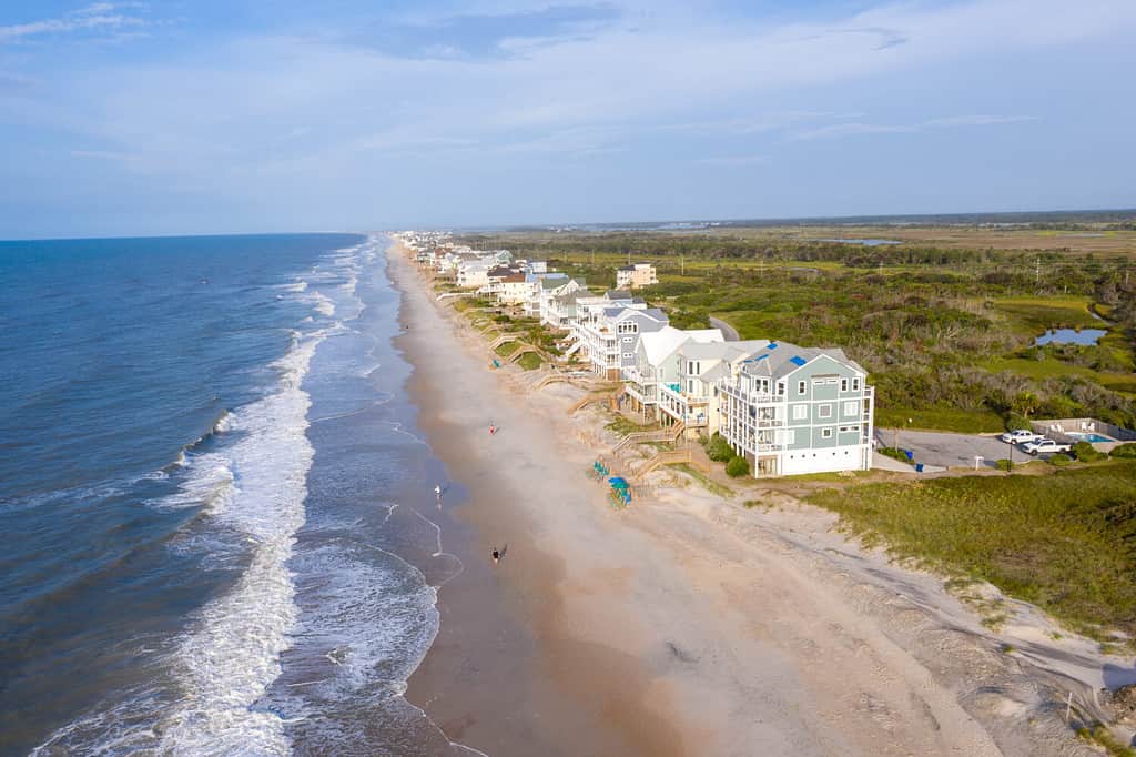 A wide angle photo of the beach and houses. 