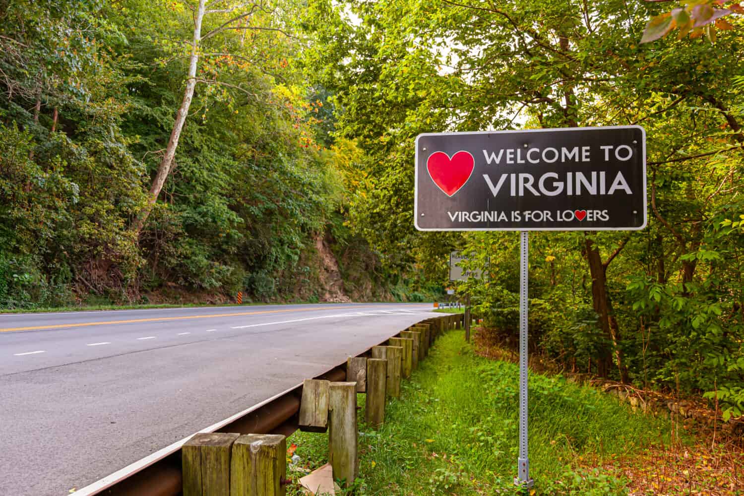 Welcome to Virginia sign located at the Maryland, Virginia state border at Purcellville, Virginia. The black sign has a red heart shape and 'Virginia is for lovers' slogan underneath.