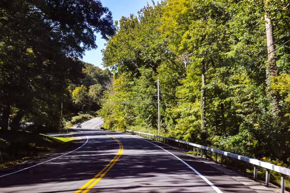 New York State highway 17-M winds its way through tranquil and scenic Orange County, New York, from Tuxedo, through Monroe, to Chester, New York, lined with trees and lush, green leaves.