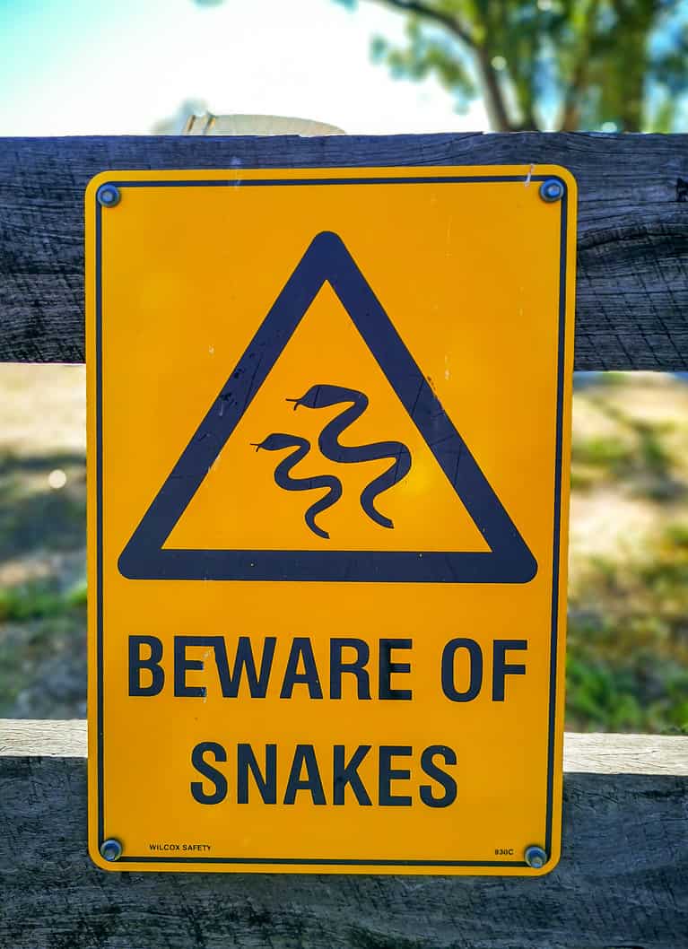Warning sign beware of snakes in infested area.