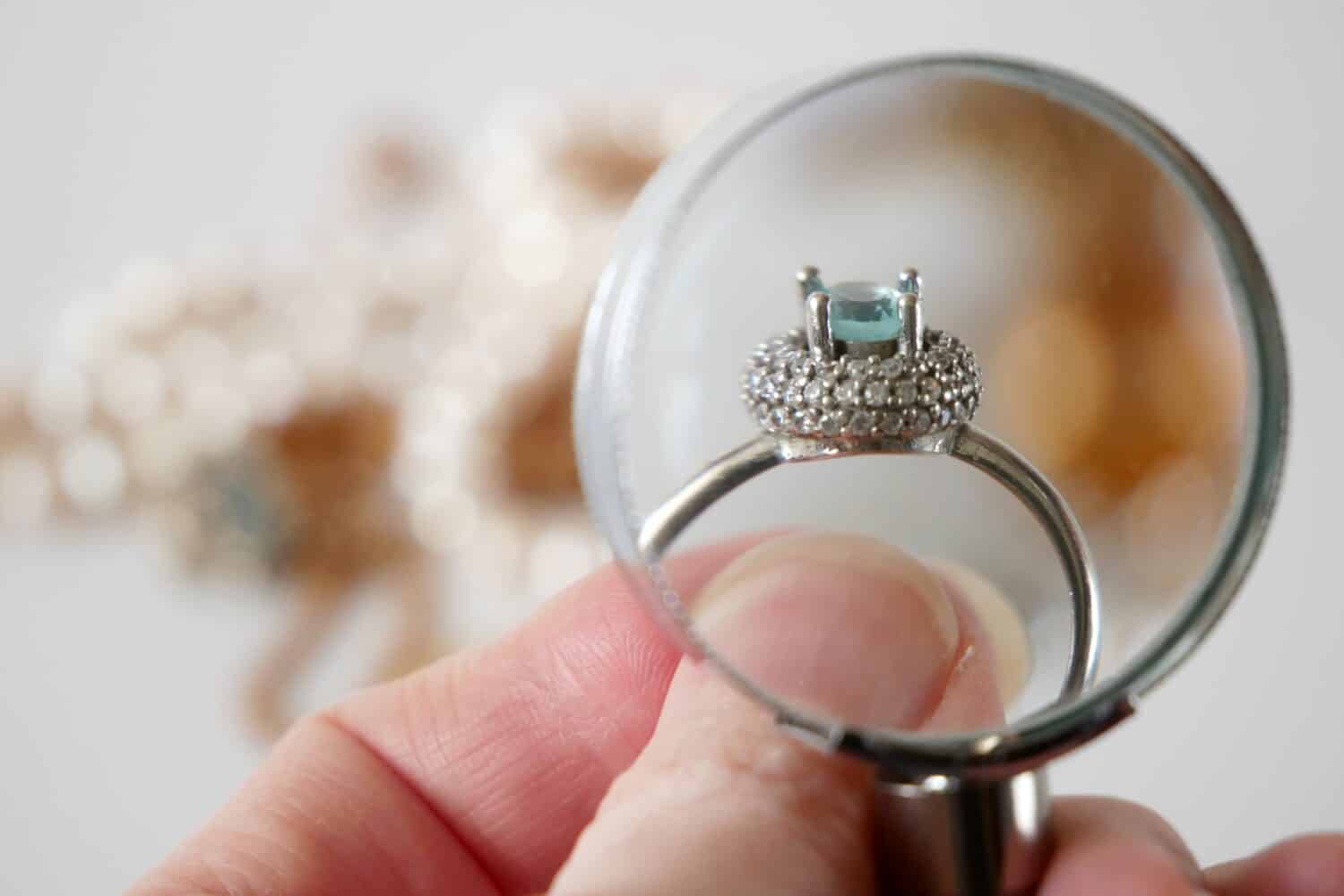 jeweler looking at ring with blue stone, jewerly inspect and verify, pawnshop concept, jewerly shop, closeup